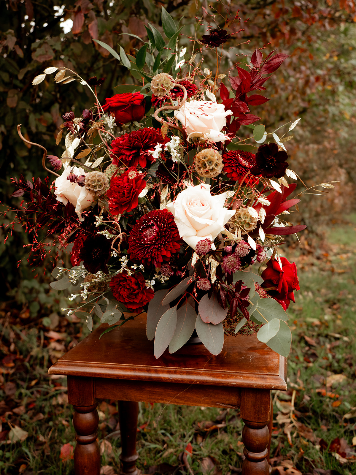 Composition florale rouge foncé, blanc et végétal