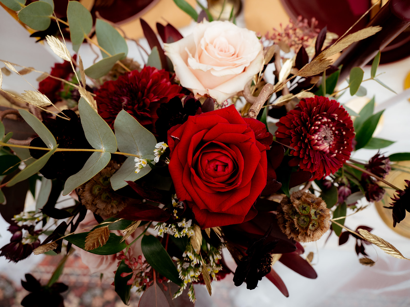 Bouquet de mariée automne hiver, rouge, végétal et blanc avec touche de doré